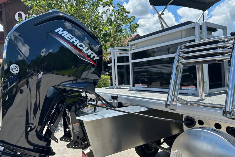 Slide: The Image of 2026 Sun Tracker Fishin' Barge 20 DLX with Mercury outboard motor, docked under blue sky. - 3