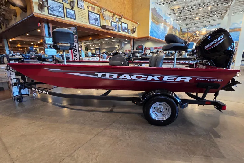 The Image of 2026 Tracker Pro 170 boat displayed indoors, featuring a sleek red design and Mercury engine. - 0
