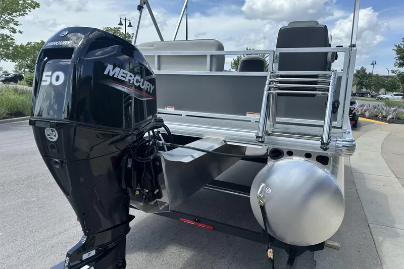 Slide: The Image of 2026 Sun Tracker Bass Buggy 16 XL Select with Mercury 50 outboard motor, parked outdoors. - 4