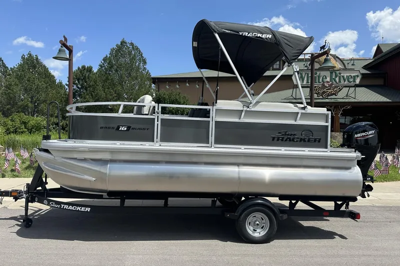 The Image of 2026 Sun Tracker Bass Buggy 16 XL Select pontoon boat on trailer, outdoors. - 0