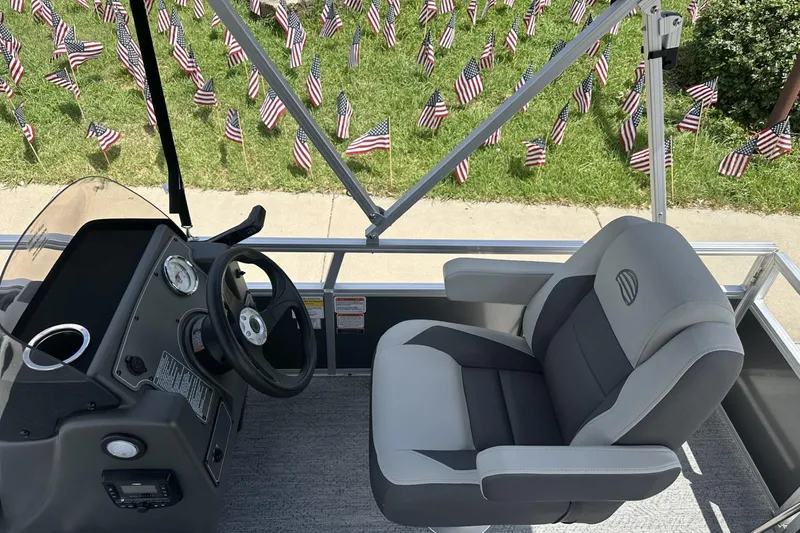 Slide: The Image of 2026 Sun Tracker Bass Buggy 16 XL Select boat interior with American flags in the background. - 11