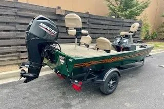 Slide: The Image of 2026 Tracker Bass Tracker Classic Limited boat with Mercury engine, parked outdoors. - 2