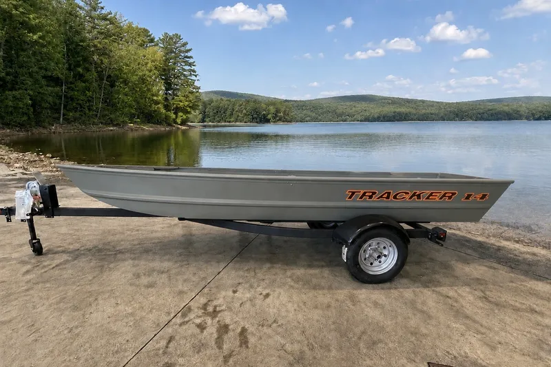 The Image of 2026 Tracker Grizzly 14 Jon boat on trailer by scenic lake. - 0