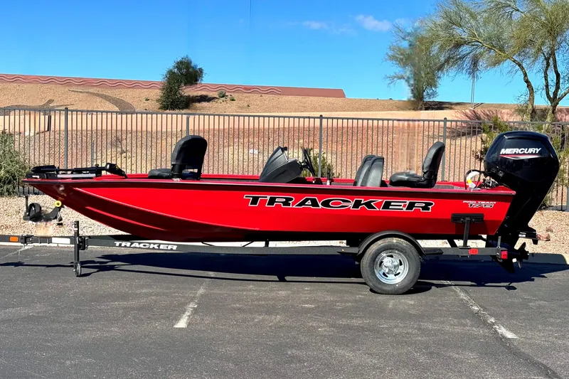 The Image of 2026 Tracker Pro Team 175 boat in vibrant red, parked on a trailer outdoors. - 0