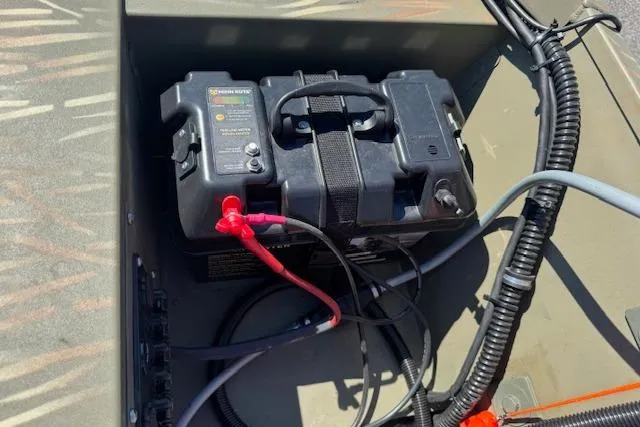 Slide: The Image of Battery compartment of 2024 Tracker Grizzly 1754 MVX Jon boat, showing wiring and connections. - 13