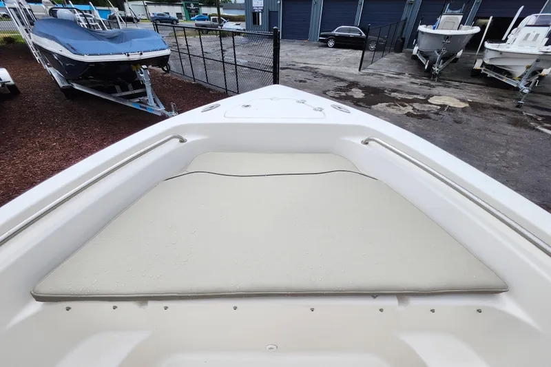 Slide: The Image of 2024 Key West 189 FS boat bow with cushioned seating in a marina setting. - 13