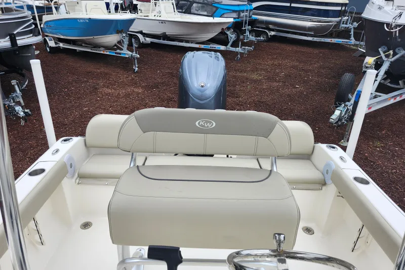 Slide: The Image of 2024 Key West 189 FS boat interior with seating and motor, displayed outdoors. - 22