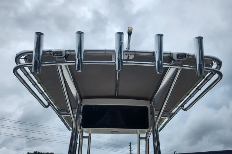 Slide: The Image of 2024 Key West 189 FS boat T-top with rod holders against cloudy sky. - 29