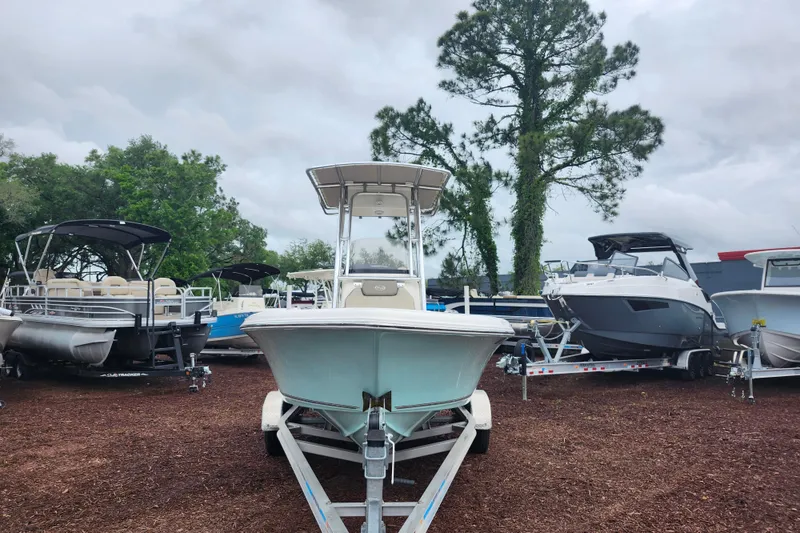 Slide: The Image of 2024 Key West 189 FS boat on trailer, surrounded by other boats, in a wooded area. - 3
