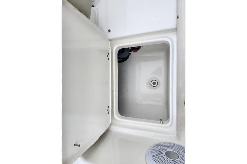 Slide: The Image of 2024 Key West 189 FS boat storage compartment with open hatch and visible speaker. - 35