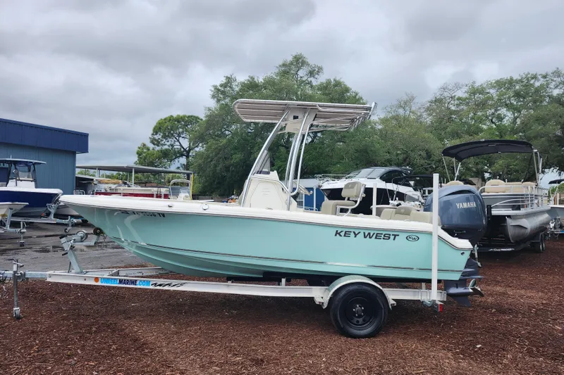 Slide: The Image of 2024 Key West 189 FS boat on trailer, displayed outdoors with other boats. - 5