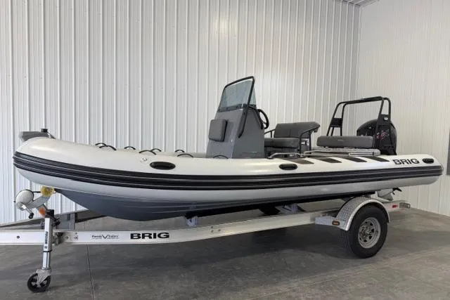The Image of 2023 Brig Navigator 610 inflatable boat on trailer in a garage setting. - 1