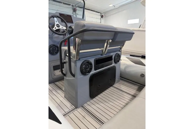 Slide: The Image of 2023 Brig Navigator 610 boat interior with steering wheel and seating area. - 3