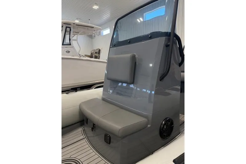 Slide: The Image of 2023 Brig Navigator 610 boat interior with seating and console in a showroom. - 4