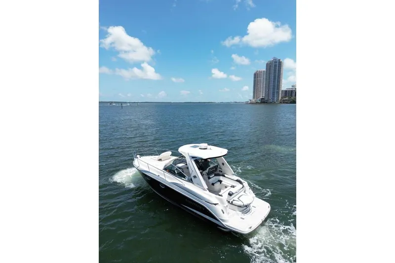 The Image of 2014 Monterey 320 Sport Yacht cruising on a sunny day near city skyline. - 1
