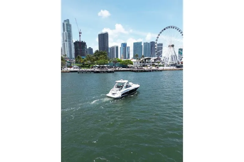 Slide: The Image of 2014 Monterey 320 Sport Yacht cruising near city skyline and Ferris wheel. - 12