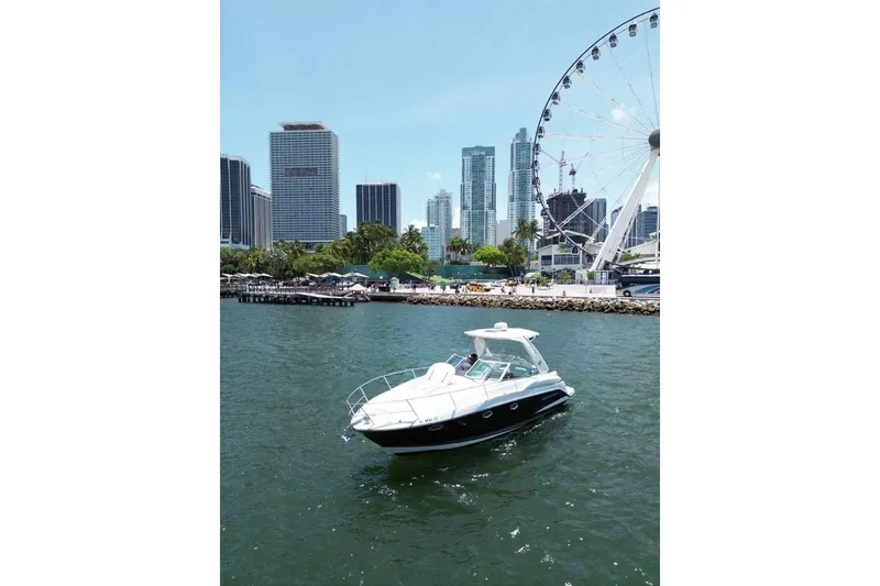 Slide: The Image of 2014 Monterey 320 Sport Yacht cruising near city skyline and Ferris wheel. - 13