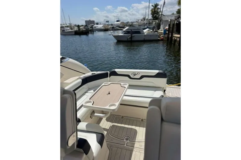 Slide: The Image of 2014 Monterey 320 Sport Yacht interior with seating and table, docked at marina. - 17