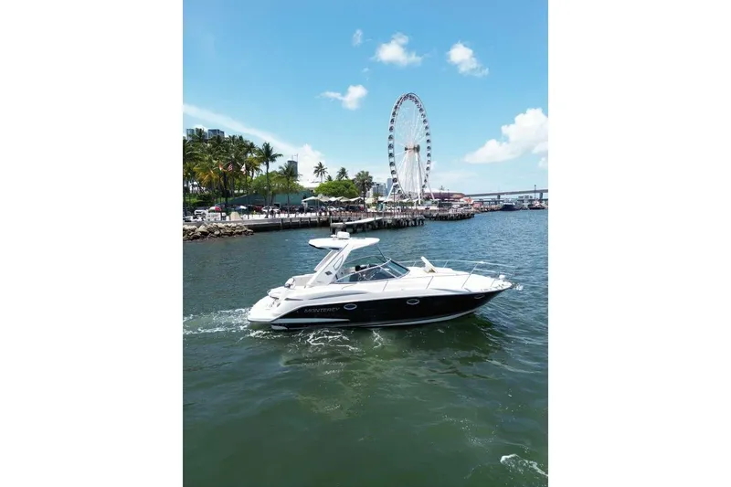 Slide: The Image of 2014 Monterey 320 Sport Yacht cruising near a waterfront with a Ferris wheel. - 4