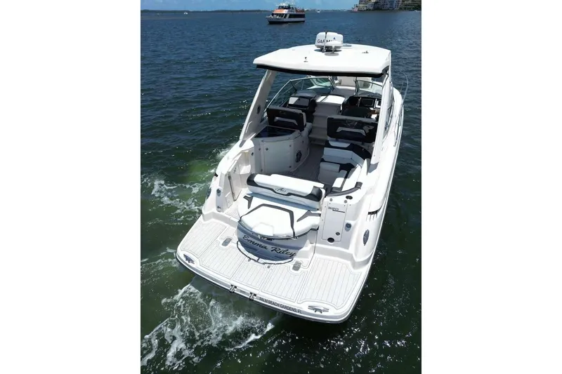 Slide: The Image of 2014 Monterey 320 Sport Yacht cruising on open water, showcasing sleek design and spacious deck. - 6