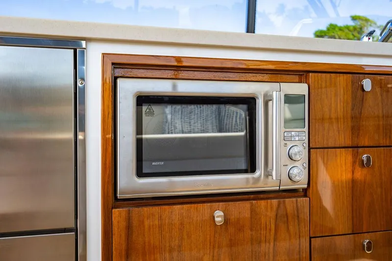 Slide: The Image of MJM 4 2024 yacht kitchen with microwave and wooden cabinetry. - 31