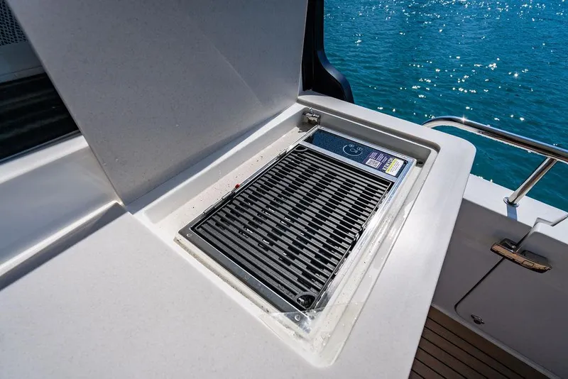 Slide: The Image of Grill on 2024 MJM 4 boat, beside blue water. - 35