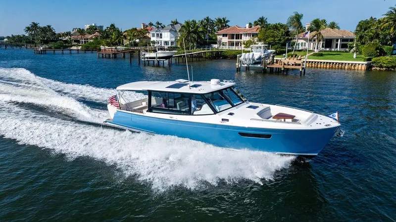 Slide: The Image of 2024 MJM 4 boat cruising on a sunny waterfront with luxury homes in the background. - 50