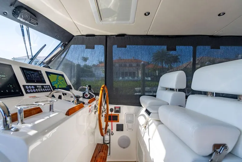 Slide: The Image of 2024 MJM 4 boat interior with modern helm, white seating, and navigation equipment. - 6