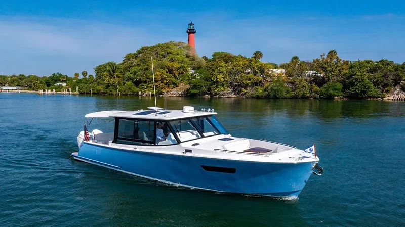 Slide: The Image of 2024 MJM 4 boat cruising near a lighthouse with lush greenery in the background. - 61