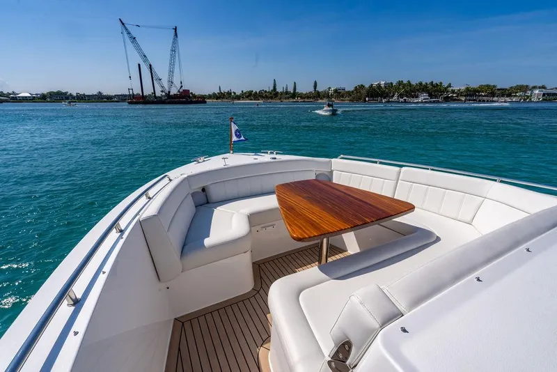 Slide: The Image of Luxurious deck of MJM 4 boat, 2024 model, with wooden table and white seating. - 9