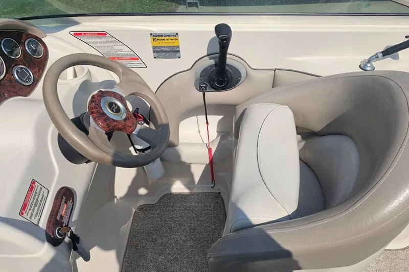 Slide: The Image of 2003 Sea Ray 220 Sundeck cockpit with steering wheel and controls. - 10