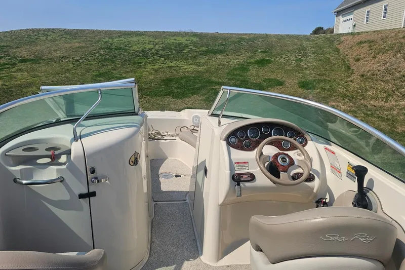 Slide: The Image of 2003 Sea Ray 220 Sundeck boat interior with steering wheel and dashboard controls. - 12