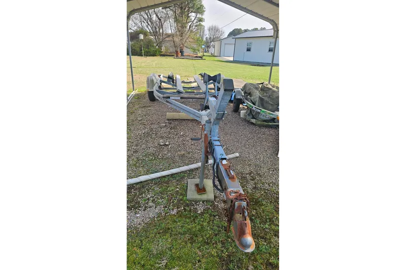 Slide: The Image of Trailer for 2003 Sea Ray 220 Sundeck, parked on gravel under a canopy. - 25