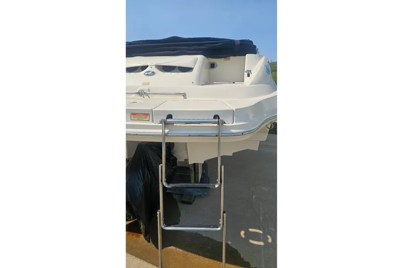 Slide: The Image of 2003 Sea Ray 220 Sundeck boat with rear ladder and covered deck. - 6