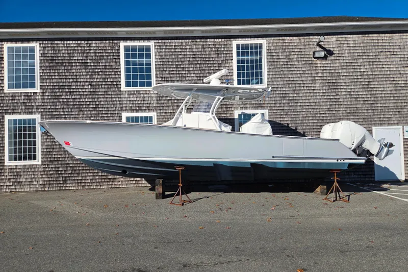 Slide: The Image of 2022 Valhalla Boatworks V-33 on stands, parked near a shingled building. - 2