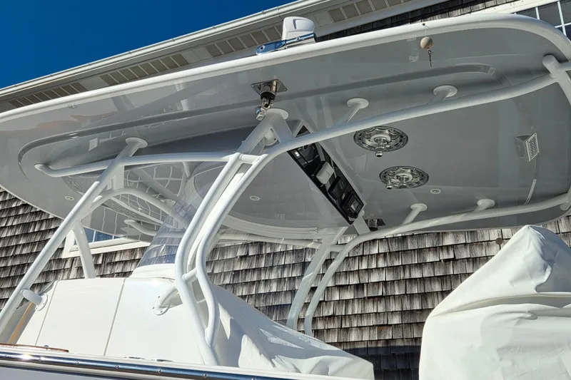Slide: The Image of 2022 Valhalla Boatworks V-33 T-top with speakers and electronics, docked near a shingled building. - 4