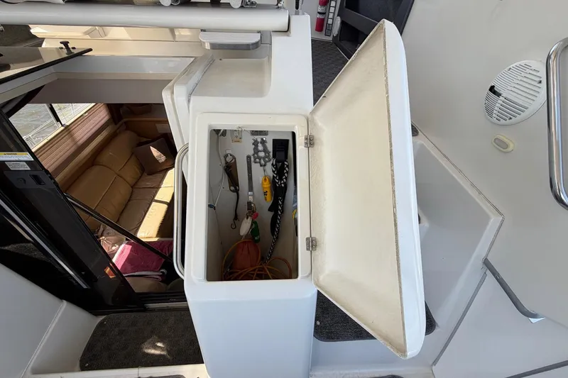 Slide: The Image of Open storage compartment on 1997 Carver 400 Cockpit Motor Yacht, revealing tools and equipment. - 15