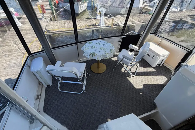 Slide: The Image of 1997 Carver 400 Cockpit Motor Yacht interior with chairs and table, dockside view. - 16