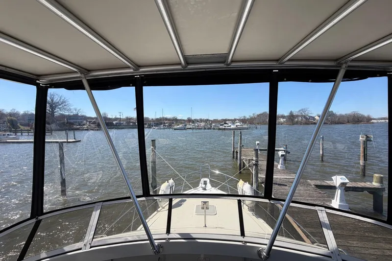 Slide: The Image of 1997 Carver 400 Cockpit Motor Yacht docked, view from cockpit overlooking serene marina. - 18