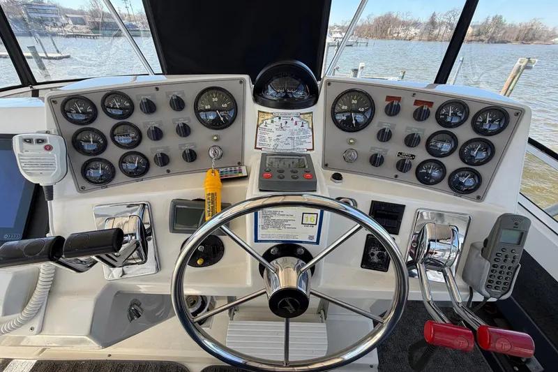 Slide: The Image of 1997 Carver 400 Cockpit Motor Yacht helm with gauges, steering wheel, and controls. - 19