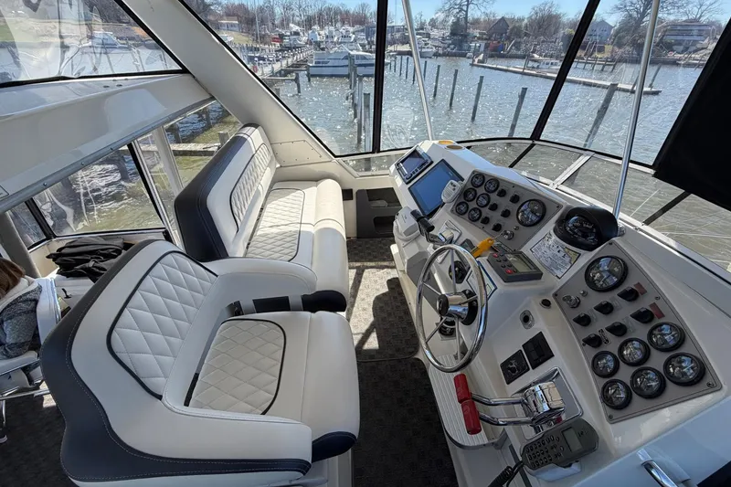 Slide: The Image of Interior view of 1997 Carver 400 Cockpit Motor Yacht helm with plush seating and control panel. - 20