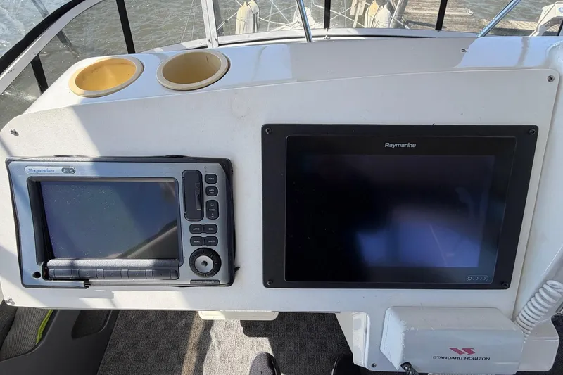 Slide: The Image of Control panel of a 1997 Carver 400 Cockpit Motor Yacht with navigation screens. - 22