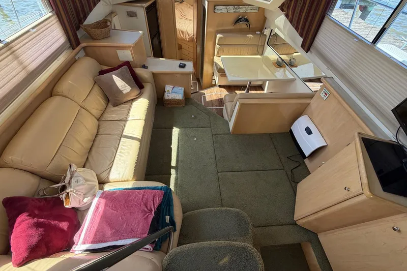 Slide: The Image of Interior of a 1997 Carver 400 Cockpit Motor Yacht with beige seating and dining area. - 28