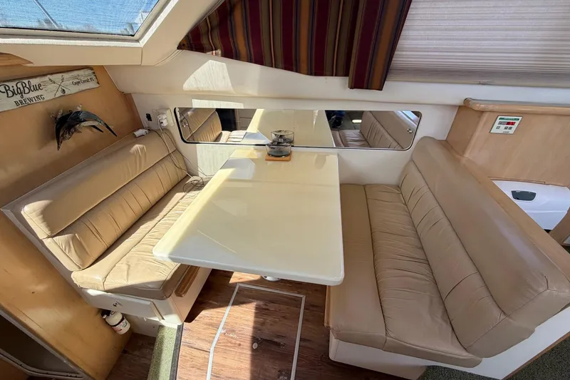 Slide: The Image of Interior of 1997 Carver 400 Cockpit Motor Yacht with beige seating and dining table. - 31