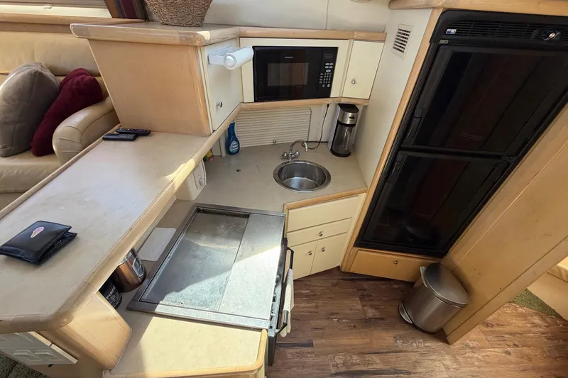 Slide: The Image of 1997 Carver 400 Cockpit Motor Yacht kitchen with microwave, sink, and refrigerator. - 32