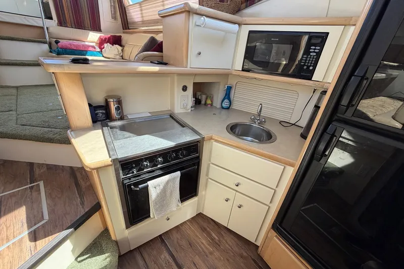 Slide: The Image of Interior of 1997 Carver 400 Cockpit Motor Yacht kitchen with stove, sink, and microwave. - 34