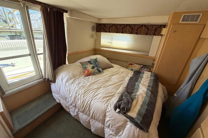 Slide: The Image of Cozy bedroom in a 1997 Carver 400 Cockpit Motor Yacht with natural light and plush bedding. - 43