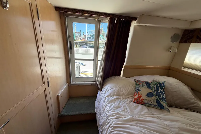 Slide: The Image of Cozy bedroom in 1997 Carver 400 Cockpit Motor Yacht with nautical-themed decor. - 44