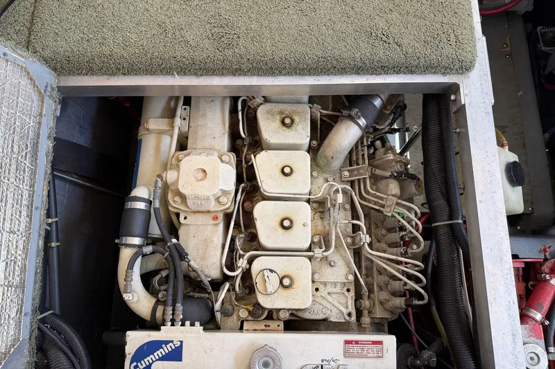 Slide: The Image of Engine compartment of a 1997 Carver 400 Cockpit Motor Yacht, featuring a Cummins engine. - 49