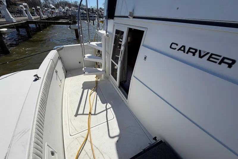 Slide: The Image of 1997 Carver 400 Cockpit Motor Yacht docked, showing cockpit area and open cabin door. - 5